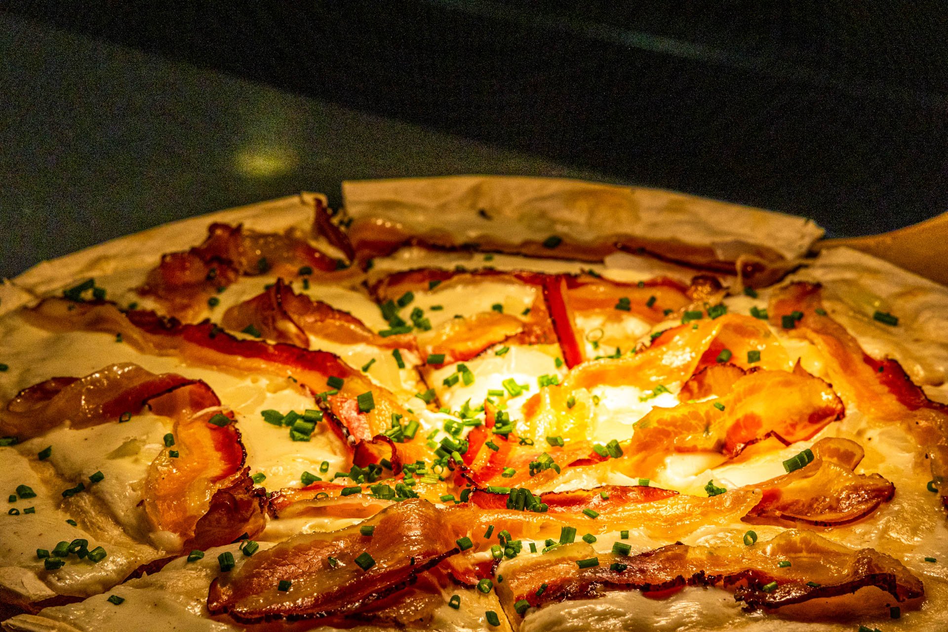 Flammkuchen mit Speck und weiteren leckeren Zutaten. 