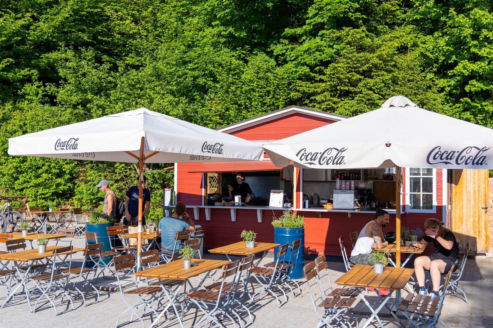 Kioskhaus in Rot zwei Sonnenschirme und Stühle und Tische